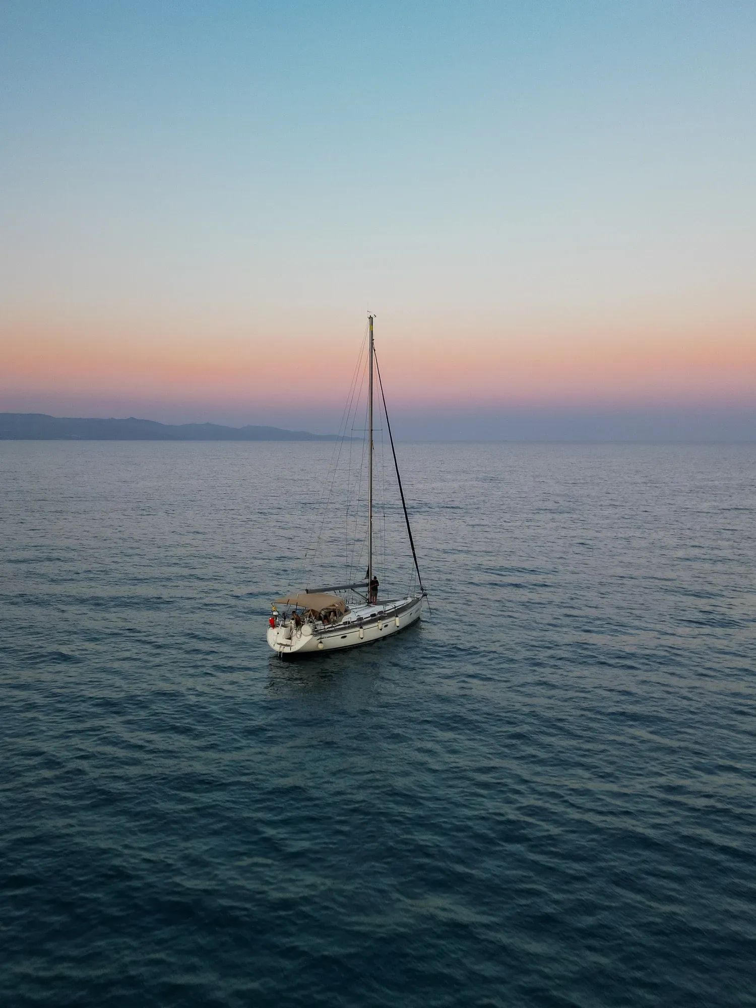 Barca a vela all'ancora al crepuscolo nel mare della Sardegna